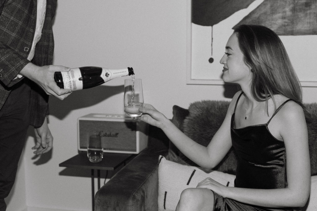 black and white photo of a couple pouring champagne