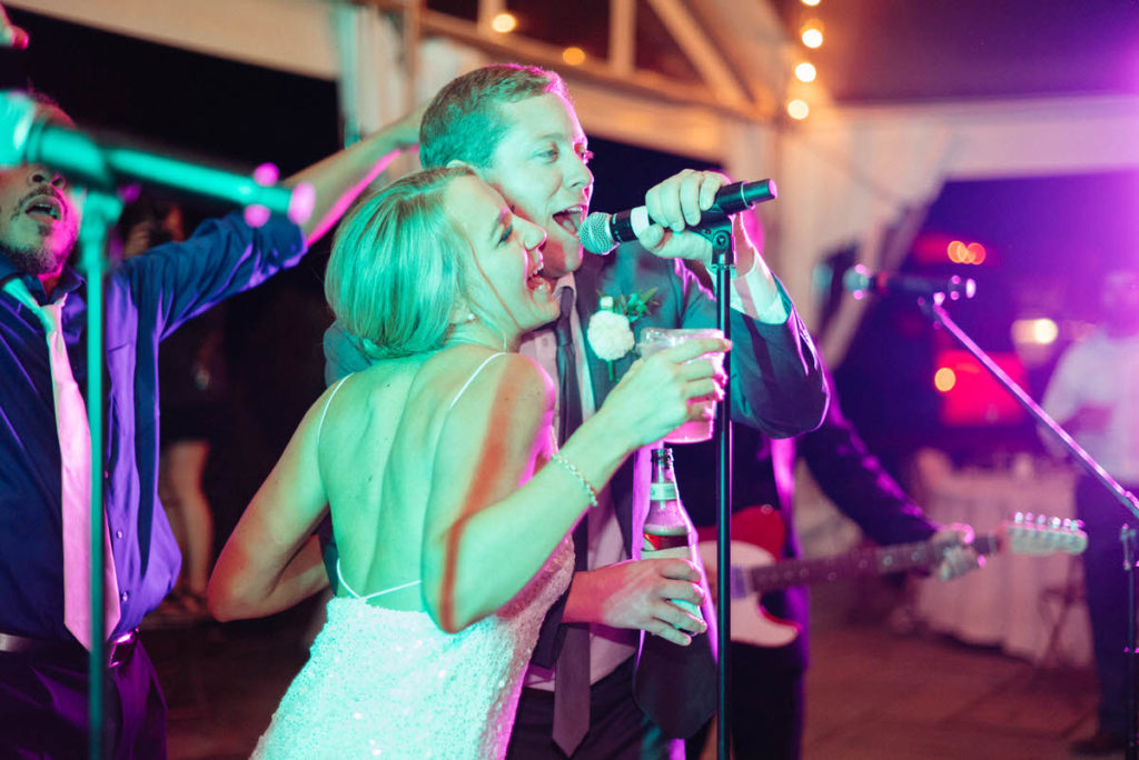 bride and groom singing karaoke at their recepiton