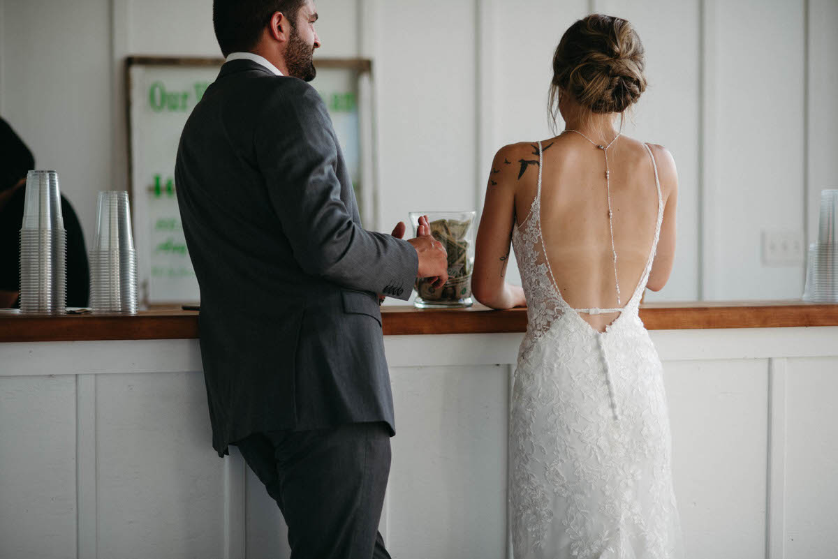 bride and groom standing at a wooden bar next to each other 