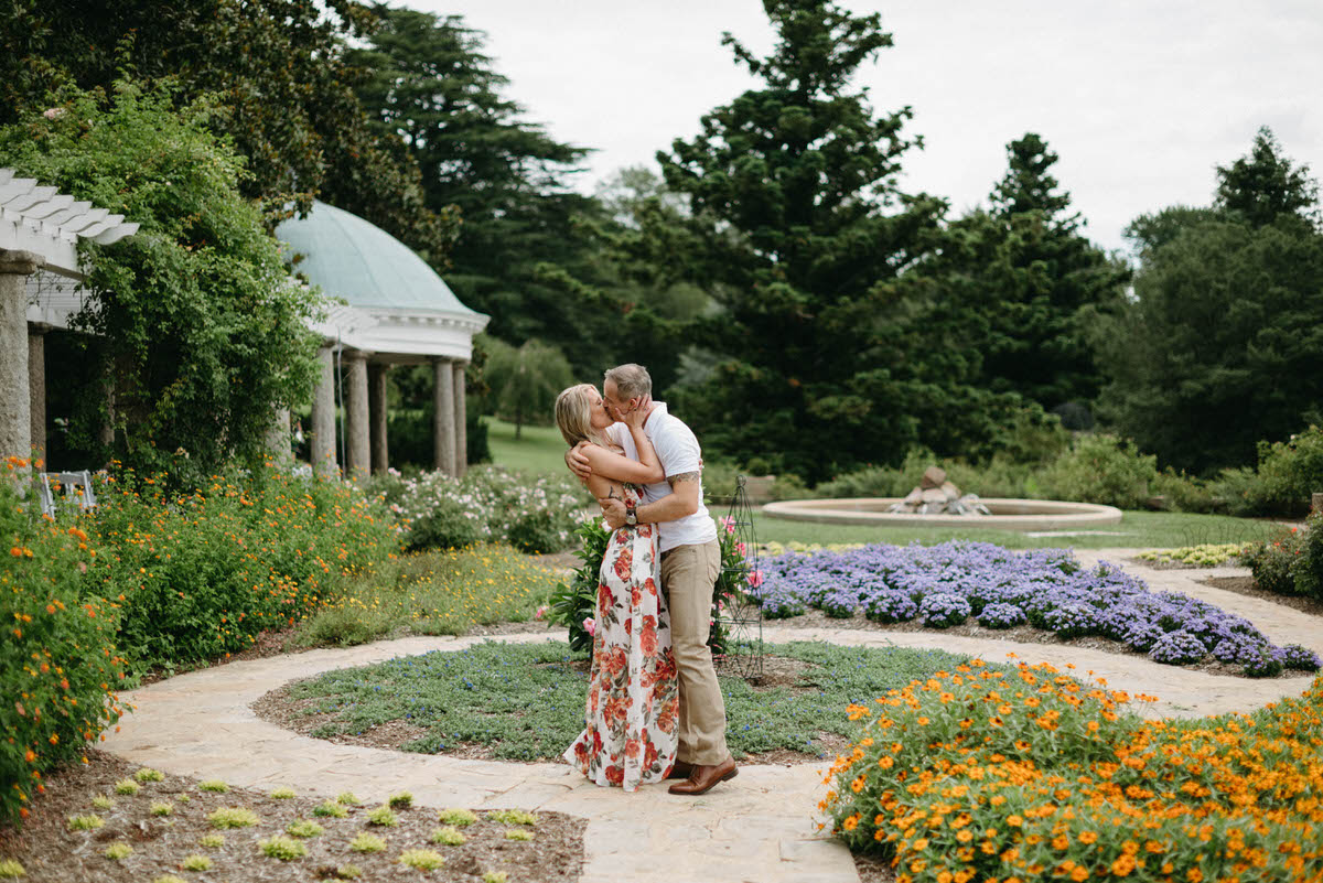 couple kissing in the middle of a large garden