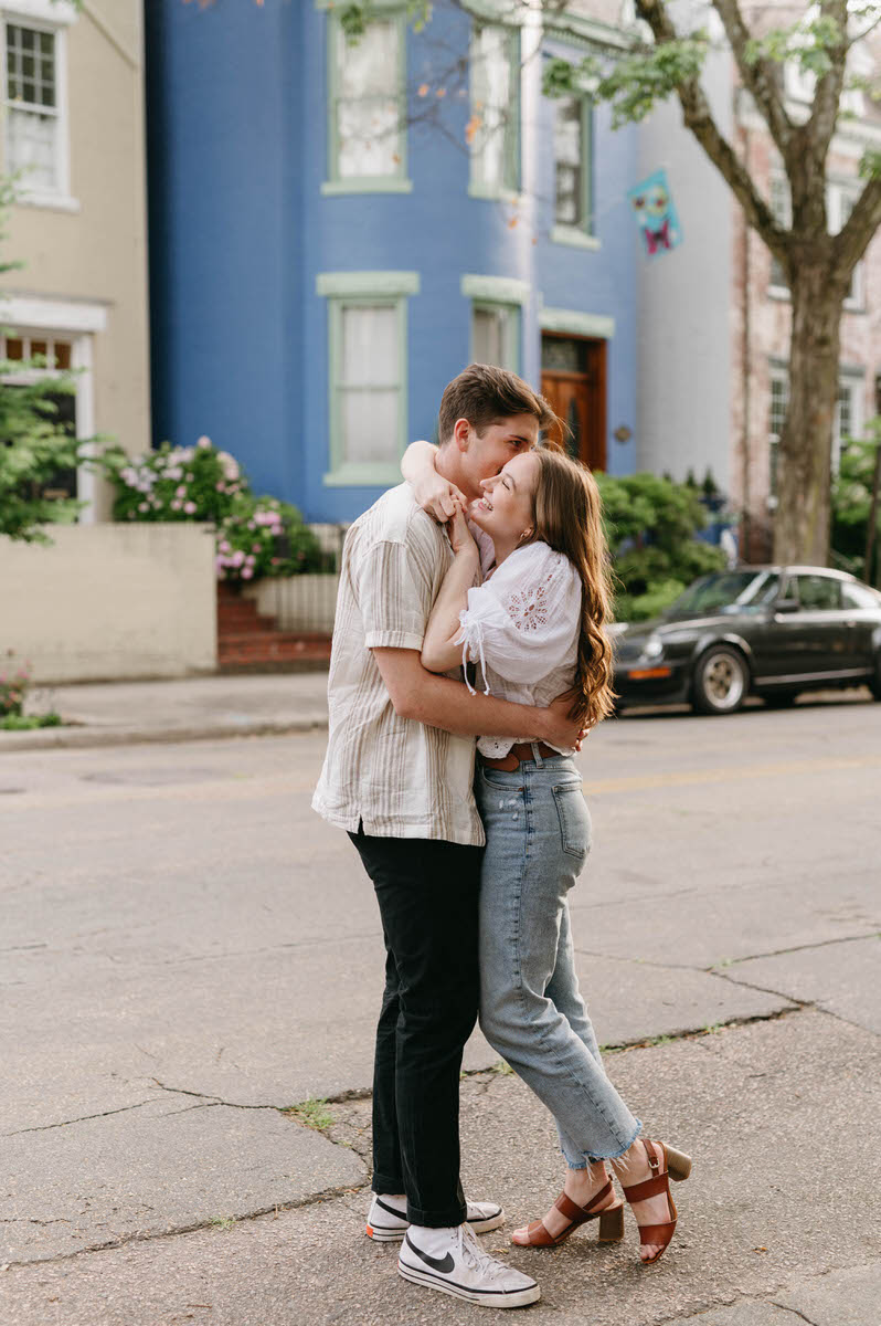 couple hugging while standing in the middle of a city street 