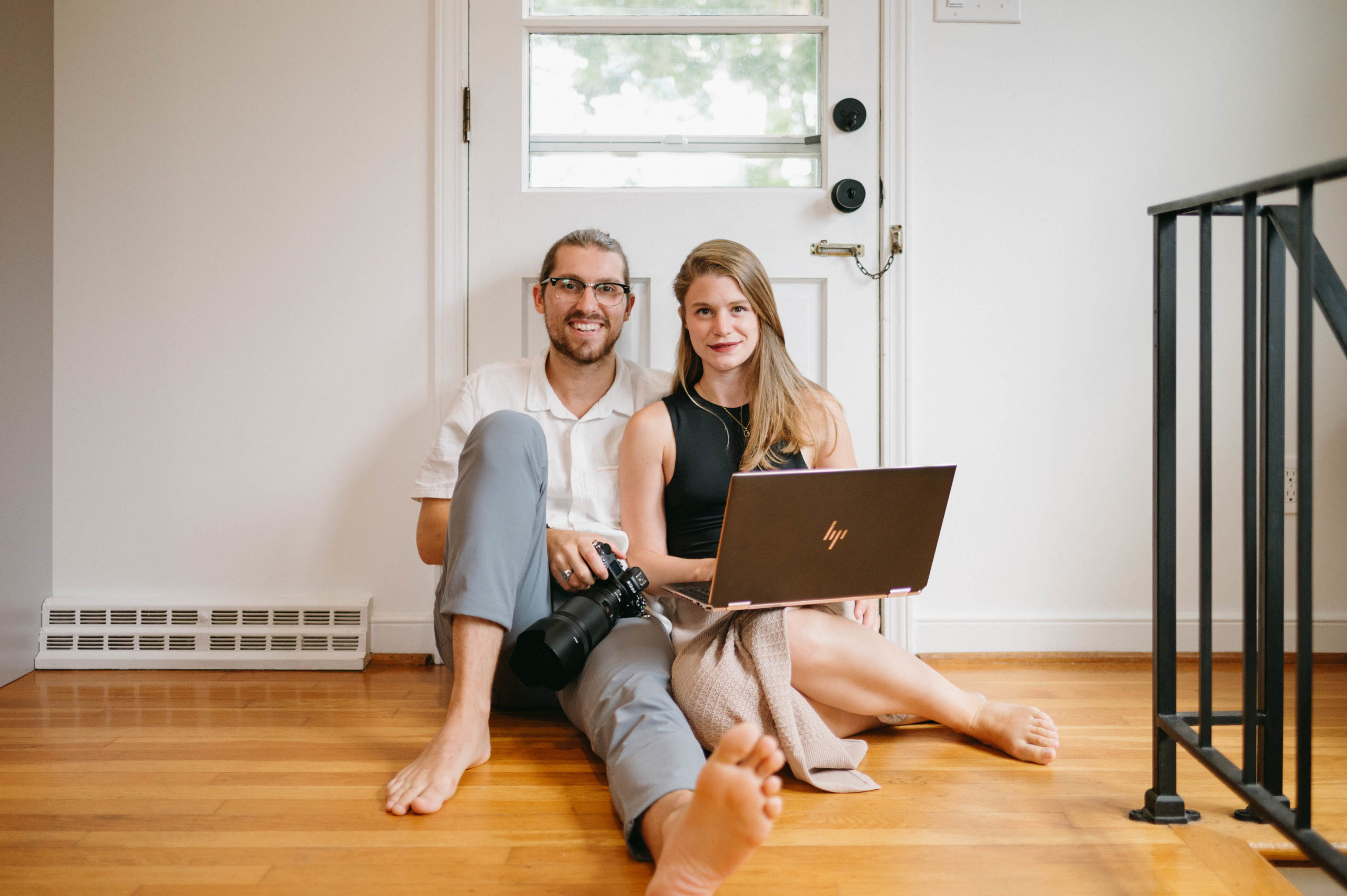 two people sitting on the floor with a laptop