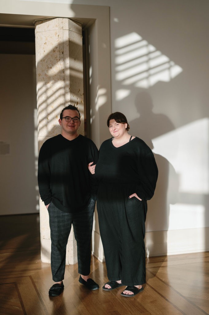 A couple stands with interesting light from shades in the VMFA