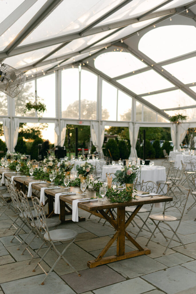 A long square wedding reception table under a tented area. 