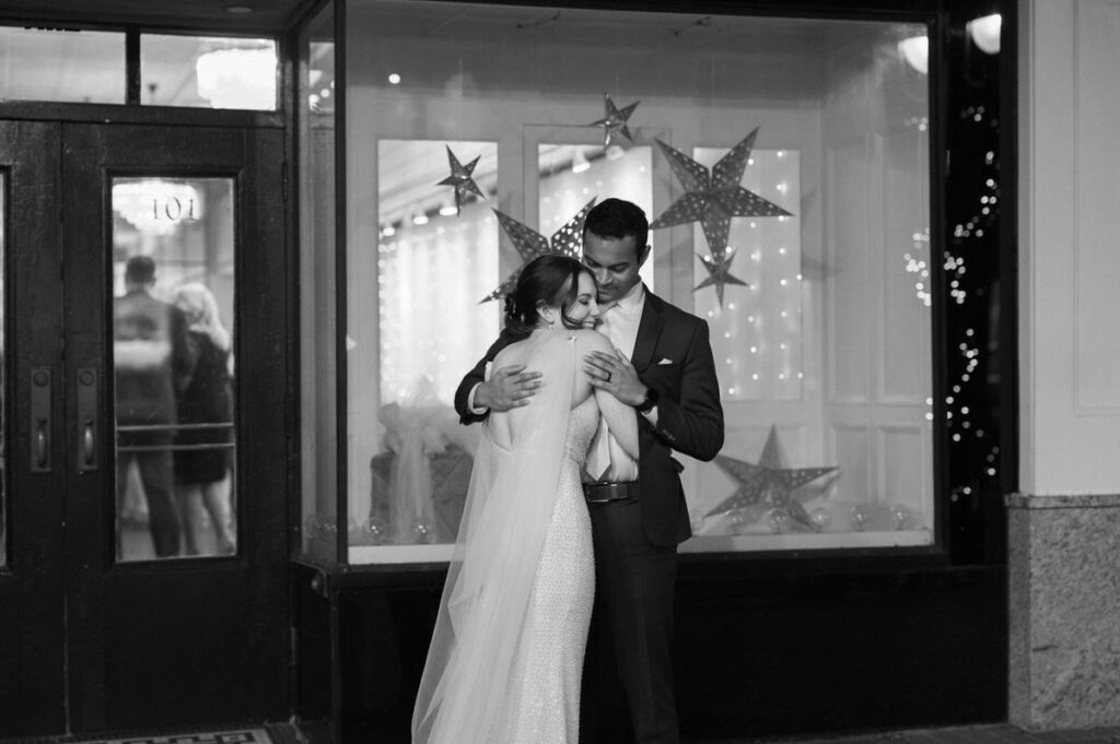 Black and white photo of a bride and groom hugging. 