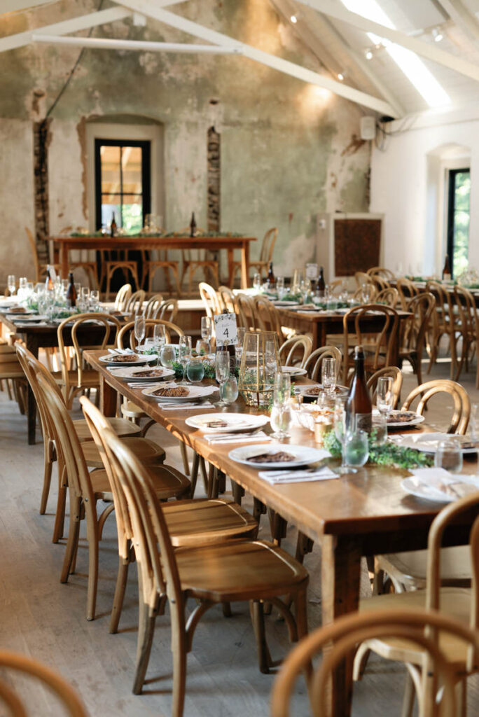 A small reception hall set up with decorated tables and chairs. 