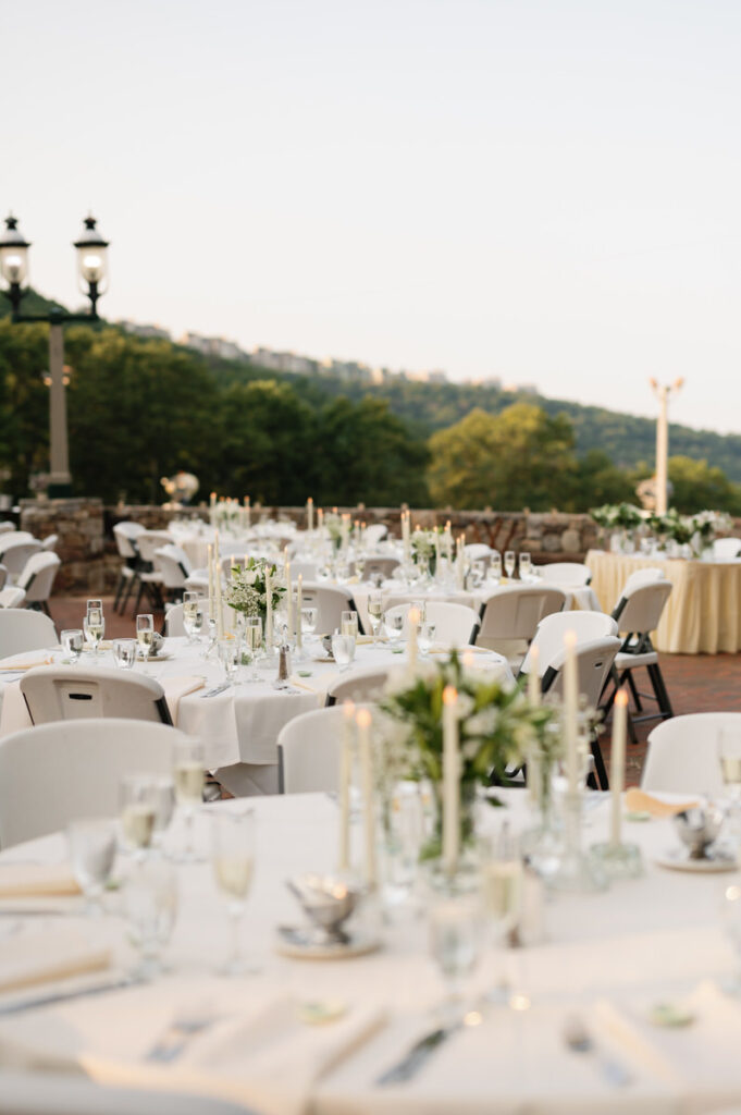 Circular wedding reception tables set up in a large open field. 