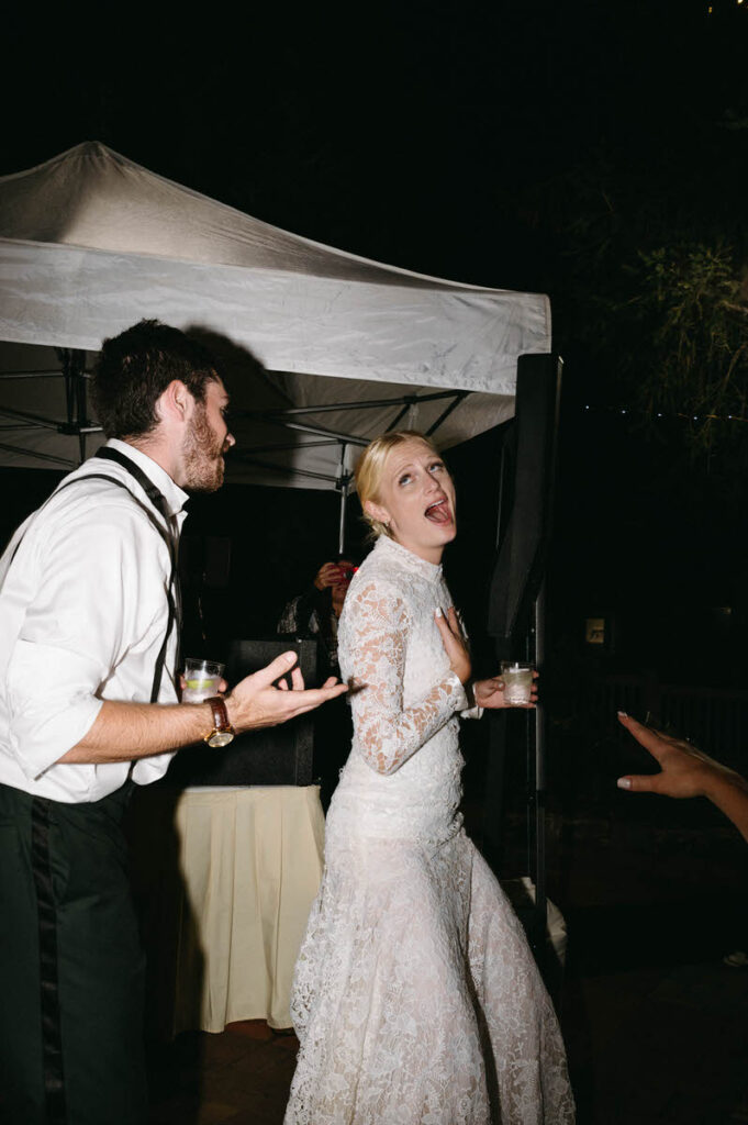 Two people singing and dancing at a wedding reception. 