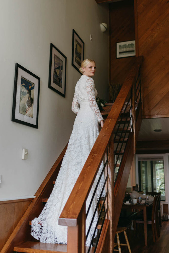 A bride walking up a staircase as she looks back over her shoulder. 