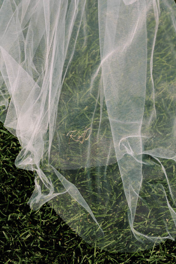 A close up view of a veil laying on the grass. 
