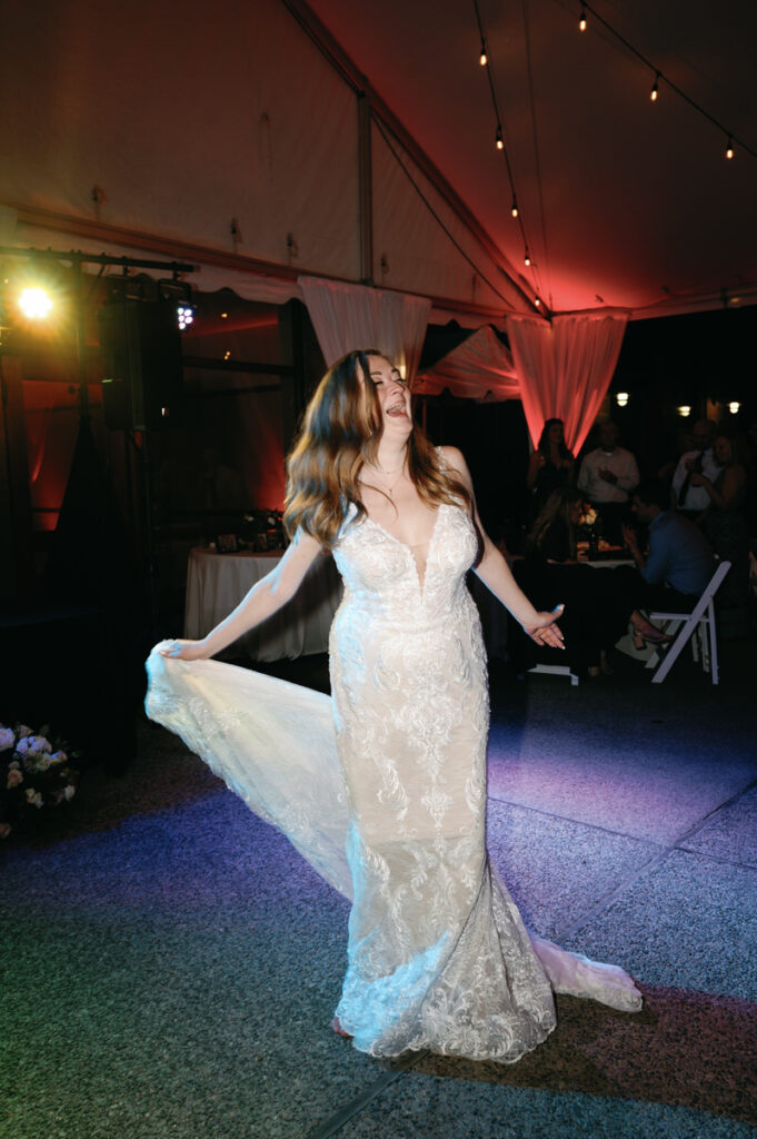 A bride dancing in the middle of a dance floor at a wedding reception. 