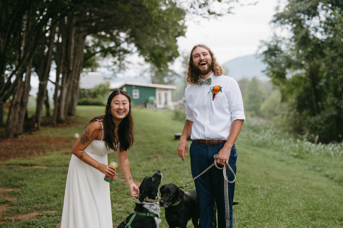 A couple standing together with the dog smiling at one of the best places to elope in Virginia.