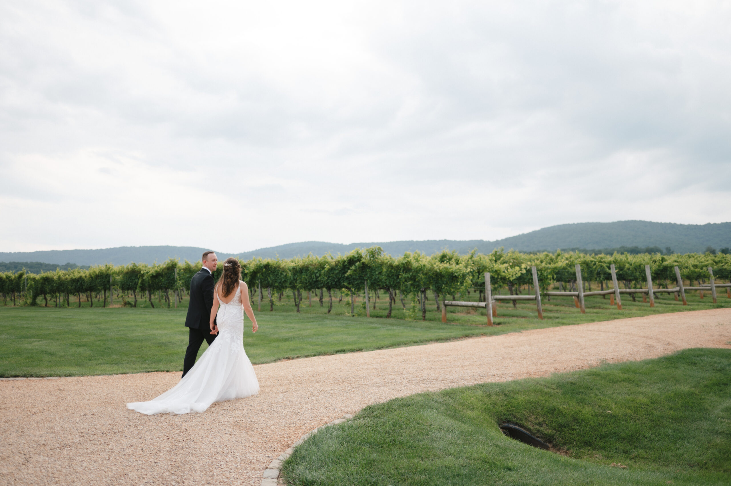 A newlywed couple walking down a gravel road at one of the best wedding venues in Orange VA