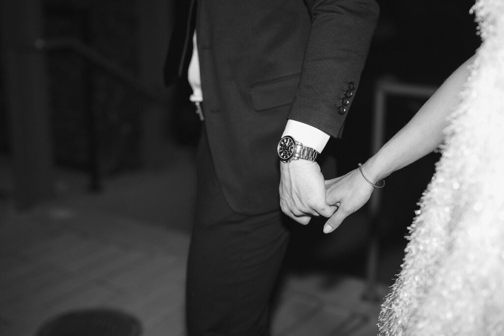 Black and white photo of a couple holding hands 