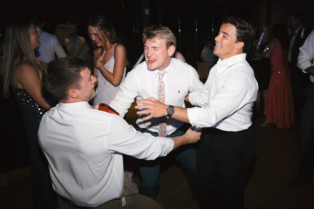 Wedding guests dancing and singing at a reception 