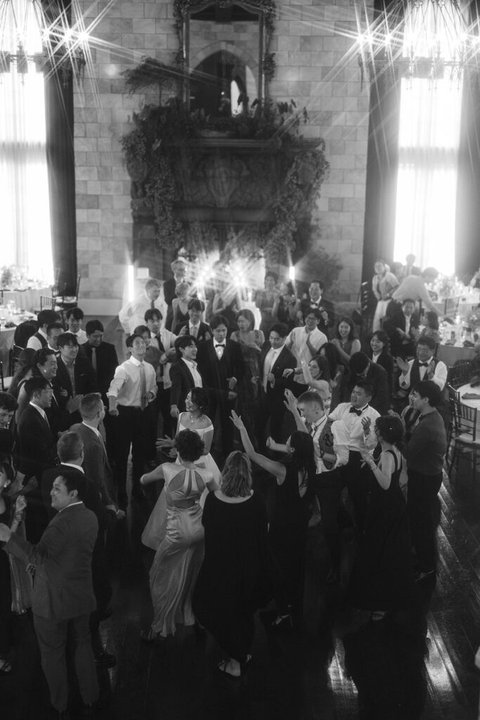 Black and white photo looking down at guests dancing at a wedding reception. 