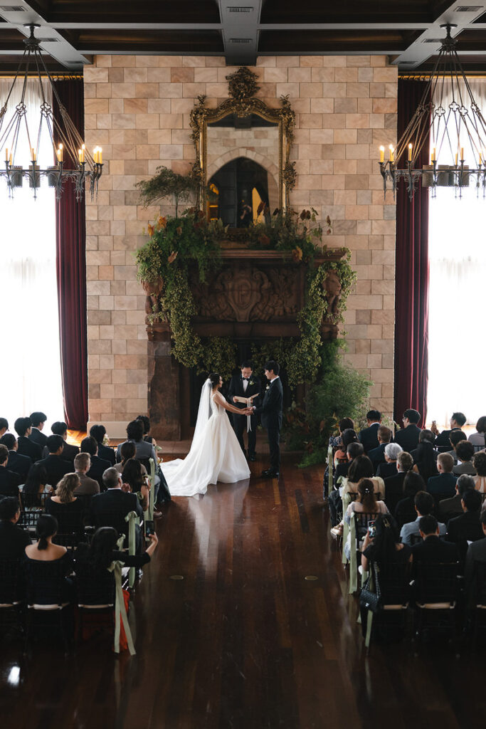 View of a couple standing up saying their vows with their guests watching on. 