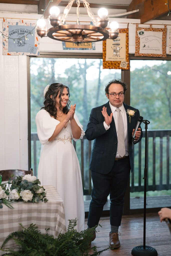 The couple claps joyfully during their reception.